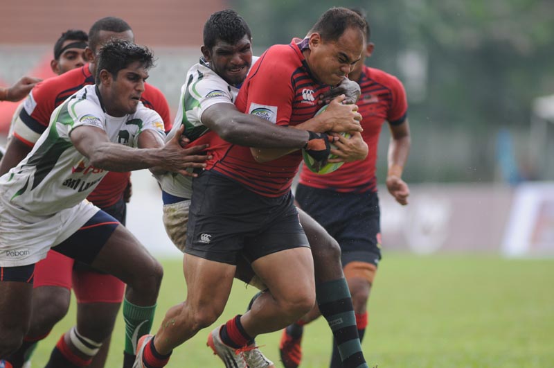 Kapten pasukan Bunga Raya, Mohd Syahir Asraf Rosli (merah) cuba melepasi halangan pemain Sri Lanka. Kredit Foto - Faiz Azizan/malaysiarugby.com
