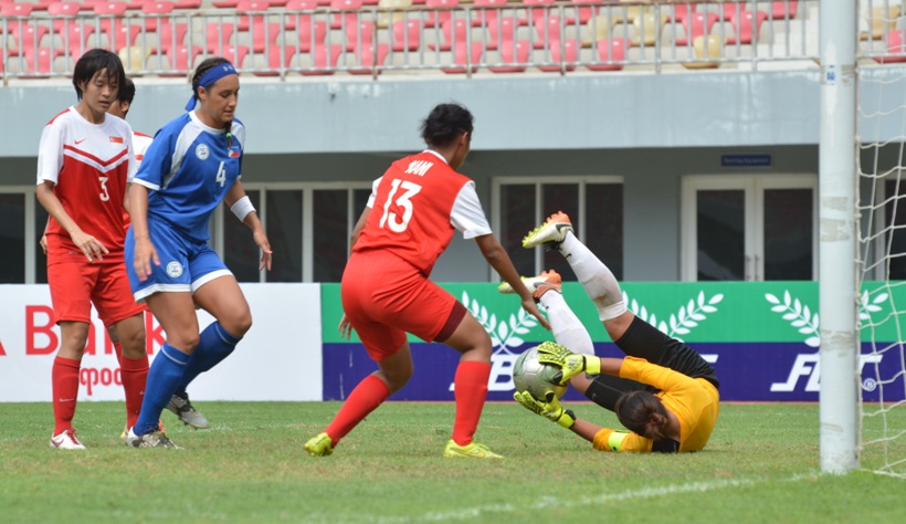 Phi (blue vs Sin (red). Sin GK Noor Kusumawati grabs the ball